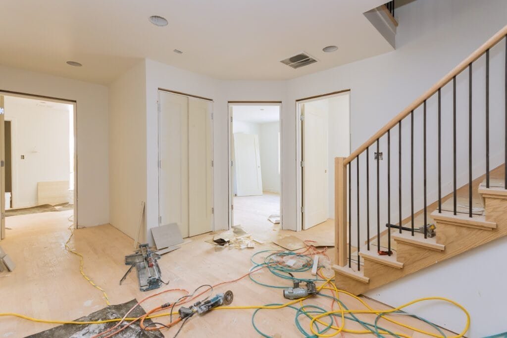 Modern home interior under construction with drywall installation and electrical wiring.